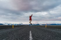 Чоловік стрибає на мальовничій дорозі — стокове фото