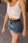 Chica en pantalones vaqueros y camiseta sin mangas - foto de stock
