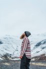 Homem barbudo em pé em montanhas nevadas — Fotografia de Stock