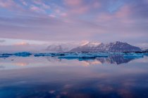 Icy lake and mountains at sunset — Stock Photo