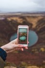 Hand taking picture of small lake — Stock Photo