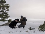 Caminhante e cão em montanhas nevadas — Fotografia de Stock