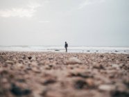 Männlicher Tourist steht an ruhigem Meer — Stockfoto