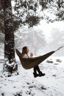 Mulher sentada na rede no inverno — Fotografia de Stock