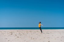 Hombre de pie en la playa de arena - foto de stock