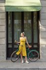 Frau steht mit Oldtimer-Fahrrad auf Straße — Stockfoto