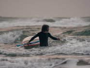 Hombre con tabla de paddle en el océano - foto de stock