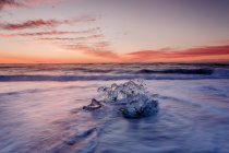 Лед на берегу на закате — стоковое фото