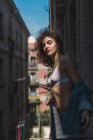 Donna in piedi sul balcone sotto il sole — Foto stock