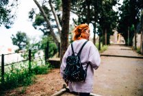 Donna con zaino passeggiando nel parco — Foto stock