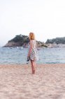 Femme portant des sandales sur la plage — Photo de stock
