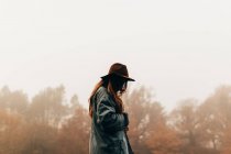 Frau mit Hut steht im Wald — Stockfoto