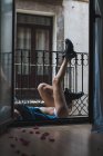 Femme couchée sur le balcon avec les jambes vers le haut — Photo de stock