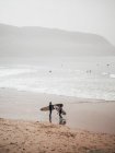 Zwei Surfer mit Brettern an der Küste — Stockfoto