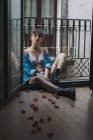 Mulher em lingerie e botas sentadas na varanda — Fotografia de Stock