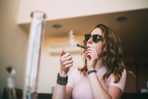 Femme fumant de la marijuana dans un verre émoussé — Photo de stock