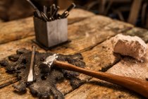 Вид на обрізку молотка та інструменти на дерев'яному металургійному столі — стокове фото