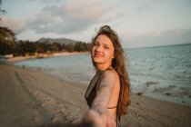 Frau hält Fotografin die Hand am Strand — Stockfoto