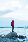 Человек в теплой одежде фотографирует озеро — стоковое фото