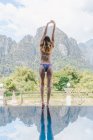 Mulher de biquíni em pé à beira da piscina — Fotografia de Stock