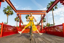 Женщина в жёлтом платье на велосипеде — стоковое фото