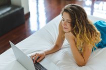 Frau benutzte Laptop auf Bett — Stockfoto