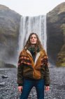 Frau steht in der Nähe des schönen Wasserfalls — Stockfoto
