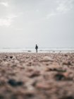 Turista masculino de pie en el océano tranquilo - foto de stock