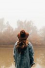 Жінка в капелюсі стоїть біля ставка — стокове фото