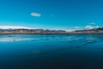 Low tide on coast and snowy mountains — Stock Photo