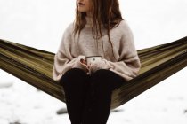 Frau sitzt im Winter in Hängematte — Stockfoto