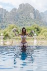 Frau im Bikini sitzt am Pool — Stockfoto