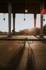 Фонари и колонны на улице с людьми, катающимися на велосипедах на заднем плане на закате — стоковое фото