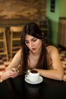 Femme assise dans un café avec du café — Photo de stock