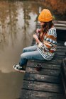 Femme assise et tricot à l'étang — Photo de stock