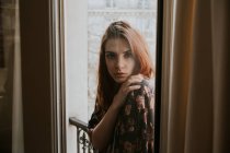 Женщина, стоящая у окна — стоковое фото
