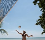 Donna che gioca a pallavolo sulla spiaggia — Foto stock