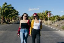 Donne che camminano su strada soleggiata — Foto stock