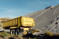 Old trailer abandoned close to a black gravel pile at a quarry — Stock Photo