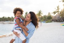 Femme avec enfant sur la plage — Photo de stock