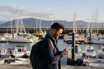 Man with backpack walking on pier — Stock Photo