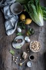 Bando de vários ingredientes para delicioso prato deitado na velha mesa de madeira perto de argamassa e pilão. — Fotografia de Stock