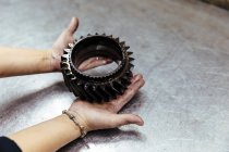 Hands holding piece of car engine — Stock Photo