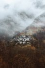 Piccolo villaggio sulla montagna nella nebbia — Foto stock