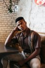 Negro hombre sentado en la cafetería - foto de stock