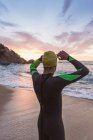 Triatleta de pé na praia arenosa — Fotografia de Stock