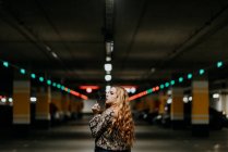 Hübsche rothaarige Frau raucht auf Parkplatz — Stockfoto