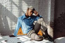 Стильний чорний чоловік сидить на підлозі — стокове фото