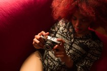 Жінка тримає камеру на дивані — стокове фото
