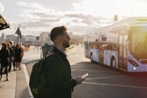 Männchen reisen stehend mit Smartphone — Stockfoto